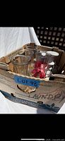Cardboard box containing vases, candlestick, ribbon, and cord