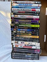 Stack of approximately 30 stand-up comedy DVDs showing spines and titles