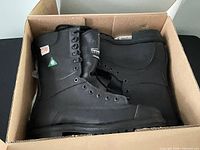 Boots inside original cardboard box showing side profile and safety rating patches