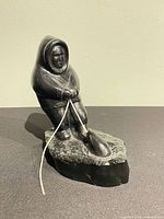 Front view of soapstone Inuit hunter pulling seal