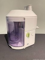 Front view showing base, purple container, green dial