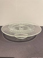 Top view of clear pressed glass cake stand showing radial pattern and circular edge