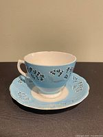 side view teacup on saucer showing pattern and gold trim wear