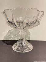 Side view of clear crystal pedestal compote bowl showing cut pattern and scalloped edge