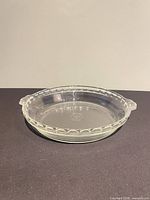 Side view of clear glass Pyrex pie plate showing overall form and handles