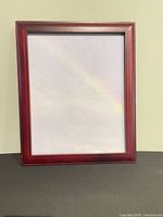 Front view of red mahogany wooden picture frame standing vertically