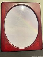 Front view of red mahogany wood frame showing oval opening and glass