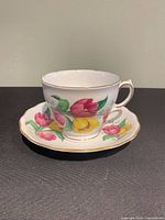 Teacup on saucer showing floral pattern and gold trim