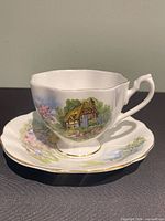 Teacup stacked on saucer showing matching cottage pattern and gold trim