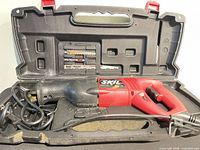 SKIL reciprocating saw inside molded carry case with blades visible in lid