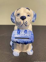 Front view showing dog shape, coin slot, blue floral painting