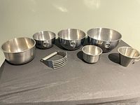 All seven stainless steel pieces arranged on surface