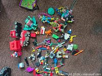 Wide view of mixed toys spread on carpet showing figures, Lego bricks, Coca-Cola trucks