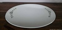 Full view of oval mirror tray showing overall shape and etched motifs