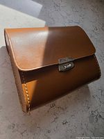 Front of brown leather clutch with clasp