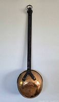 Full view of copper ladle hanging showing overall form