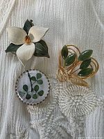 All three brooches grouped for overall view