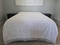 Full view of white chenille bedspread on queen bed showing fringe