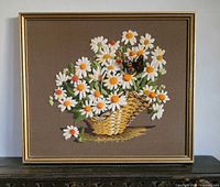 Full view of framed crewel embroidery showing basket of daisies and monarch butterfly