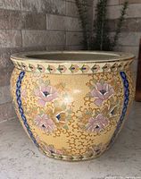 Front view of Saisuma porcelain fish bowl planter showing yellow enamel floral decoration and cobalt blue borders