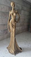 Full front three-quarter view of entire gold lady statue