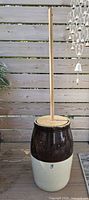 Full view of stoneware churn with wooden lid and dasher assembled