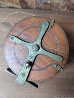 Front view of wooden reel showing brass cross brace and overall wear