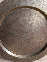 Close view of engraved brass plate surface