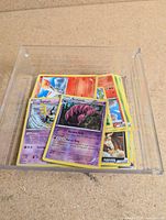 Stack of Pokémon cards in clear plastic tray