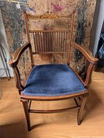 Full view of chair front showing wood frame, inlay, blue seat