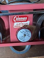 Front view showing Coleman label, burner, control valve