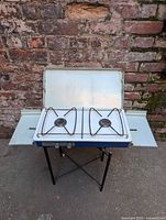 Stove open showing two burners, wire grate, side shelves extended