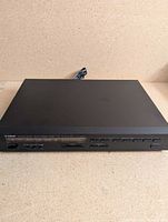 Front angled view of Yamaha T-70 tuner showing overall condition and attached power cord