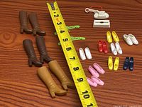 Overview of all Barbie footwear pieces with measuring tape for scale