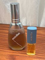 Two Estée fragrance bottles showing size difference and fill levels