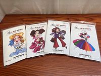 Group shot of four packaged Loralie Designs art stamps