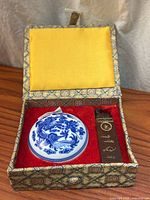 Open presentation box showing porcelain ink pot and soapstone seal inside