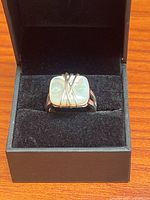 front view of ring in box showing cabochon and X overlay
