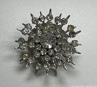 Full view of rhinestone starburst brooch front