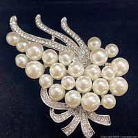 Front view of brooch showing faux pearls, rhinestones, bouquet design