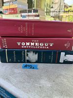 Spine view of three stacked hardcover books: On Food and Cooking, The Vonnegut Encyclopedia, Encyclopedia of Philosophy Supplement