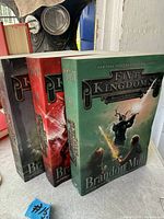 Front angled view of three books showing covers and spine numbers II-IV