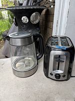 Black+Decker 2-slice toaster beside glass-stainless electric kettle