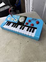 Top view of entire Little Tikes blue keyboard showing keys, buttons, knobs, and microphone