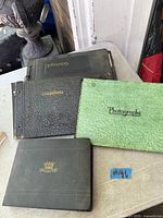 Four photo albums arranged on table showing covers