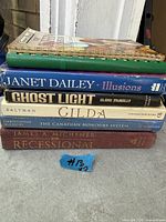 Stack of seven books showing visible titles on spines