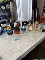Full lot of assorted cologne and perfume bottles on table