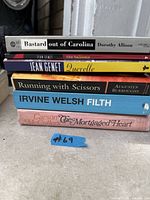 Stack of five paperback books showing titles and authors
