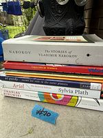 Stack of six paperback books showing visible titles and wear