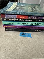 Stack of six paperback novels showing spines and titles